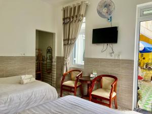 1 dormitorio con 2 camas, mesa y TV en Villa - Hotel Nam Khang 2 Dalat, en Da Lat