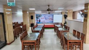 een klaslokaal met tafels en stoelen en een wit scherm bij Phú Hồng 1 Hotel in Sầm Sơn