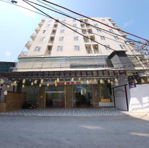 a large white building with a store front at Hoa Lư Hotel in Sầm Sơn