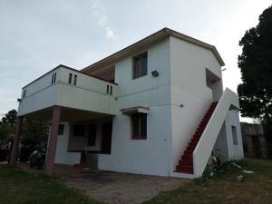 a white house with a staircase in front of it at Caron Niron Two Bedroom Villa in Kodaikānāl