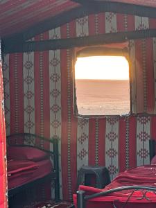 a bedroom with red and white striped walls and a window at Wadirum sunset camp in Wadi Rum