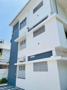 een wit gebouw met een blauwe en witte gevel bij Asian Nest Serviced Apartments in Cochin