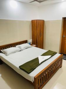 een bed in een slaapkamer met een groene deken erop bij Asian Nest Serviced Apartments in Cochin