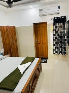 um quarto com uma cama e uma porta de madeira em Asian Nest Serviced Apartments em Cochin