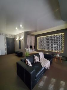 a living room with a black leather couch at CosHOME - apartament in Chişinău