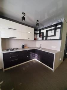 a kitchen with black and white cabinets and a sink at CosHOME - apartament in Chişinău