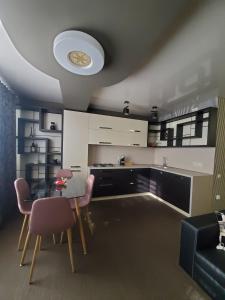 a kitchen with a table and chairs and a ceiling at CosHOME - apartament in Chişinău