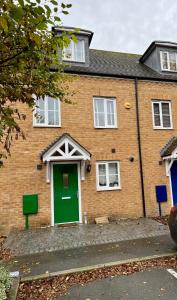 een stenen huis met een groene deur in een straat bij Comfort Home in Gillingham