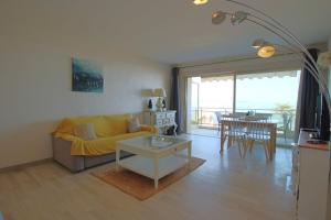 uma sala de estar com um sofá amarelo e uma mesa em Apartment Seaside em Cannes