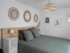 um quarto com uma cama com dois espelhos na parede em La maison aux bambous em Montreuil