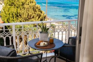 a table with a plate of bread and a drink on a balcony at Mare Nostrum Seafront Apartment in Zakynthos Town