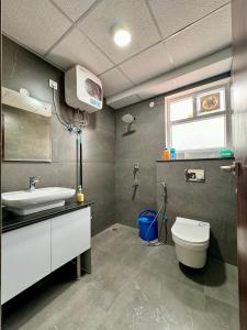 ein Bad mit einem Waschbecken, einem WC und einem Fenster in der Unterkunft Zen Den in Zirakpur