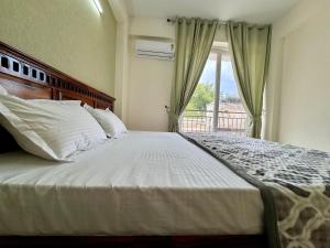 Schlafzimmer mit einem großen Bett und einem Fenster in der Unterkunft Zen Den in Zirakpur