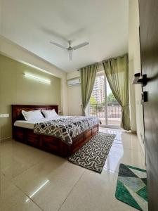 ein Schlafzimmer mit einem Bett und einem großen Fenster in der Unterkunft Zen Den in Zirakpur