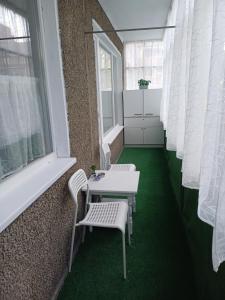 a room with two chairs and a table and a window at Maya's Airport Apartment in Sofia