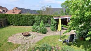 a garden with a yellow umbrella and a chair at Ferienhaus Berndt im Spreewald in Lübbenau