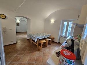 a living room with a table and bench in a room at Casa Monique in Badalucco
