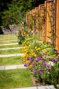 a garden with colorful flowers next to a fence at The Old Manse of Blair, Boutique Hotel & Restaurant in Blair Atholl
