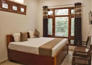 a bedroom with a large bed and a window at The Tree Lounge in Bhīm Tāl