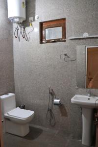 a bathroom with a toilet and a sink at The Tree Lounge in Bhīm Tāl +29 photos