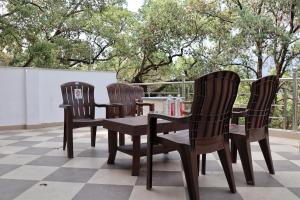 three chairs and a table on a patio at The Tree Lounge in Bhīm Tāl
