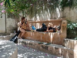dos personas sentadas en un banco con una guitarra en Tabassam Guest House, en Lamu