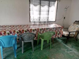 Zimmer mit Stühlen, einem Tisch und einem Fenster in der Unterkunft Tabassam Guest House in Lamu
