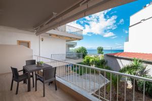 ネア・ムダニアにあるSabbia Apartments Seafront by RentalsPro - Nea Moudania Halkidikiの海の景色を望むバルコニー(テーブル、椅子付)