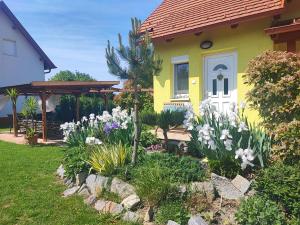 una casa con un jardín con flores en el patio en Éva Háza Nyugalom/Pihenés/Relax, en Sopron