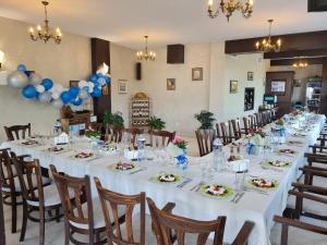 una mesa larga en una habitación con globos azules y blancos en Family Hotel Bela, en Tryavna