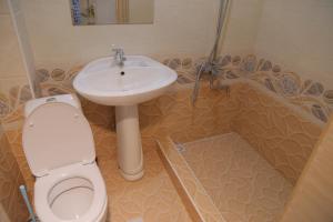 ein Bad mit einem WC und einem Waschbecken in der Unterkunft URGANCH Hotel in Urganch
