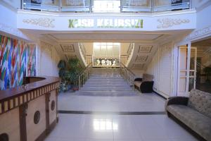a lobby with stairs and a sign that says kisselieli sidx at URGANCH Hotel in Urganch