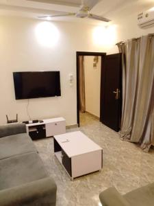 a living room with a couch and a flat screen tv at Appartement meublé Pantagruel in Abomey-Calavi