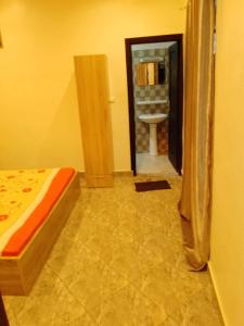 a bedroom with a bed and a bathroom with a sink at Appartement meublé Pantagruel in Abomey-Calavi