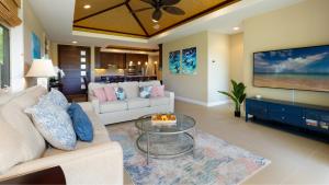 a living room with a couch and a glass table at HOUSE OF MANTA Light and Airy Access to Private Beach Club in Waikoloa