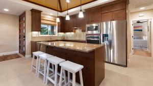 a kitchen with a center island with bar stools at HOUSE OF MANTA Light and Airy Access to Private Beach Club in Waikoloa