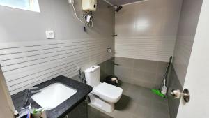 Łazienka z białą toaletą i umywalką w obiekcie The soiree w mieście Thiruvalla
