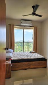 sypialnia z łóżkiem i dużym oknem w obiekcie The soiree w mieście Thiruvalla