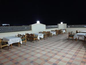 a row of tables and chairs on a patio at night at Sharq Plaza in Bukhara