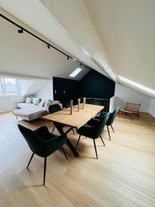 uma sala de jantar com uma mesa de madeira e cadeiras verdes em Duplex hyper centre em Liège