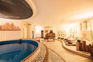 a large indoor pool in a hotel room with a swimming pool at Hotel Wildschütz in San Leonardo in Passiria