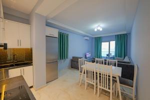 a kitchen and living room with a table and a dining room at Vila Bana in Qeparo
