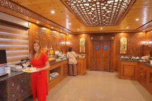a woman holding a plate of food in a kitchen at Petra Plaza Hotel in Wadi Musa