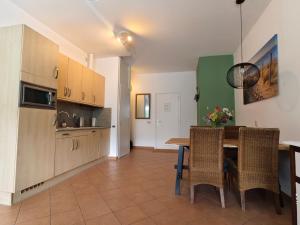 a kitchen and dining room with a table and chairs at Appartement Wijde Blick 1.11 - Callantsoog aan Zee in Callantsoog