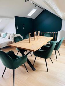 comedor con mesa de madera y sillas verdes en Duplex hyper centre, en Lieja