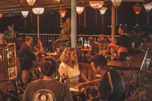 a group of people sitting at a restaurant at Phong Nha Jasmine Hostel & Roof Top Bar in Quang Binh