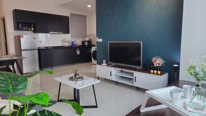 uma sala de estar com uma televisão e uma cozinha em NEW Sunway Greenfield Home 2-6pax 5mins to Sunway Pyramid em Petaling Jaya