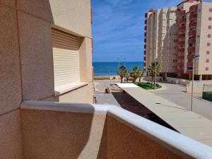 a balcony with a view of the ocean and buildings at Apartamentos Las Palmeras V.v. in La Manga del Mar Menor