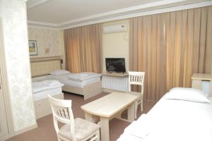 Zimmer mit 2 Betten und einem Zimmer mit einem Bett und einem TV in der Unterkunft URGANCH Hotel in Urganch