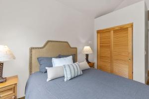 1 dormitorio con 1 cama azul y 2 almohadas en Affordable Mountain Lodge Ski in Ski out en Telluride